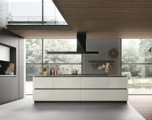 Isola in materico Cemento Bianco con blocco cottura in marmo Petit Granit. Composizione a portale in Pet Grau opaco e materico Cemento Bianco. Top in materico Cemento Bianco.